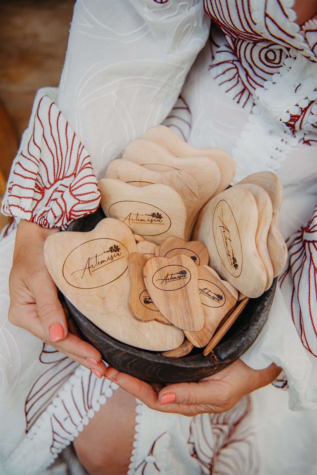 Gua Sha sirsniņas bļodā, turētas rokās